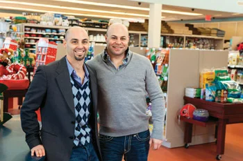 Adam and Ari Jacobson standing in the aisle of a Pet Pantry Warehouse store at Christmas